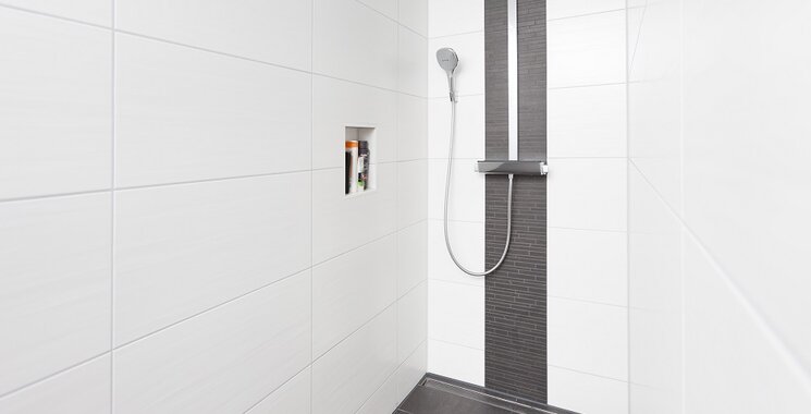 weiße fliesen mit schwarzem mosaik in dusche