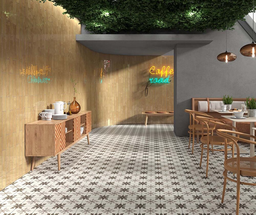 Gelbe Wandfliesen kombiniert mit gemusterten Bodenfliesen im Retro-Look in einem modernen Cafébereich.