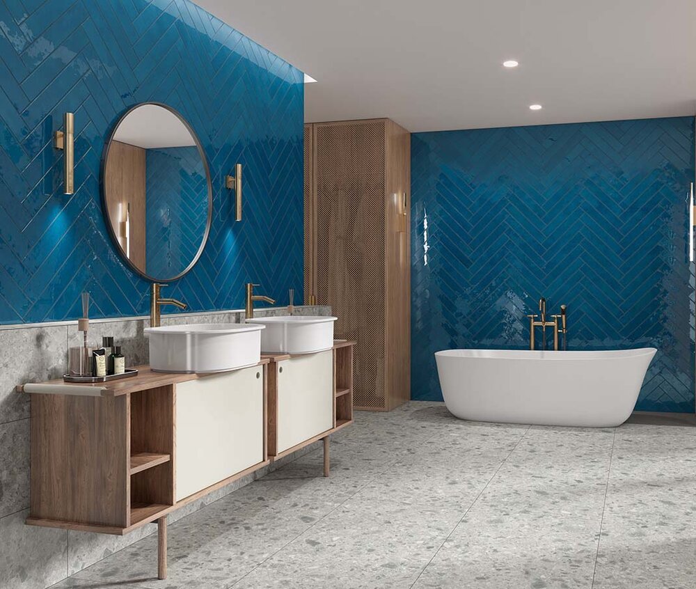 Kobaltblaue Wandfliesen im Fischgrätmuster mit glänzender Oberfläche in einem modernen Badezimmer mit freistehender Badewanne.