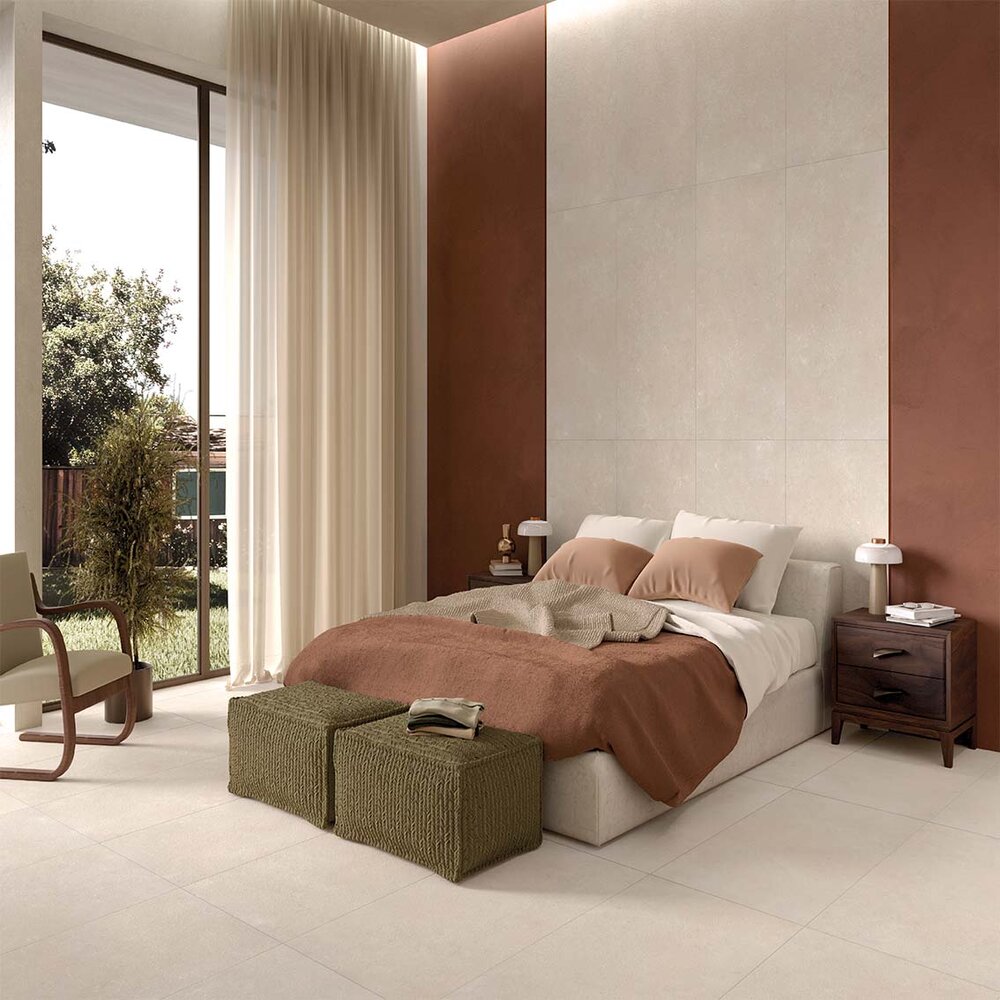 Natursteinoptik-Fliese im hellen Schlafzimmer mit warmen Farben und großen Fensterfronten