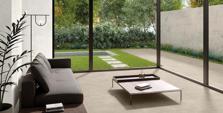 Großformatige Natursteinoptik-Fliese auf Terrasse und im Wohnzimmer mit Blick ins Grüne