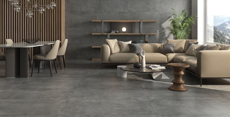Wohnbereich mit großflächig verlegten Fliesen Cannigione in grauer Betonoptik, kombiniert mit gemütlicher Einrichtung und Wandverkleidung in Holz