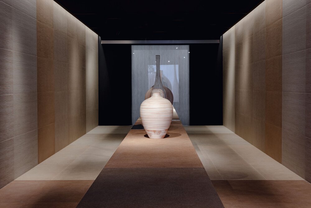 Moderner Ausstellungsraum mit Sennariolo Fliesen, warmen Lichtakzenten und architektonischer Klarheit