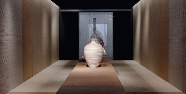 Moderner Ausstellungsraum mit Sennariolo Fliesen, warmen Lichtakzenten und architektonischer Klarheit