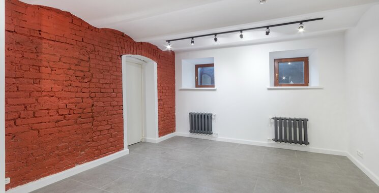 Kellerraum mit grauen Fliesen und roter Backsteinwand