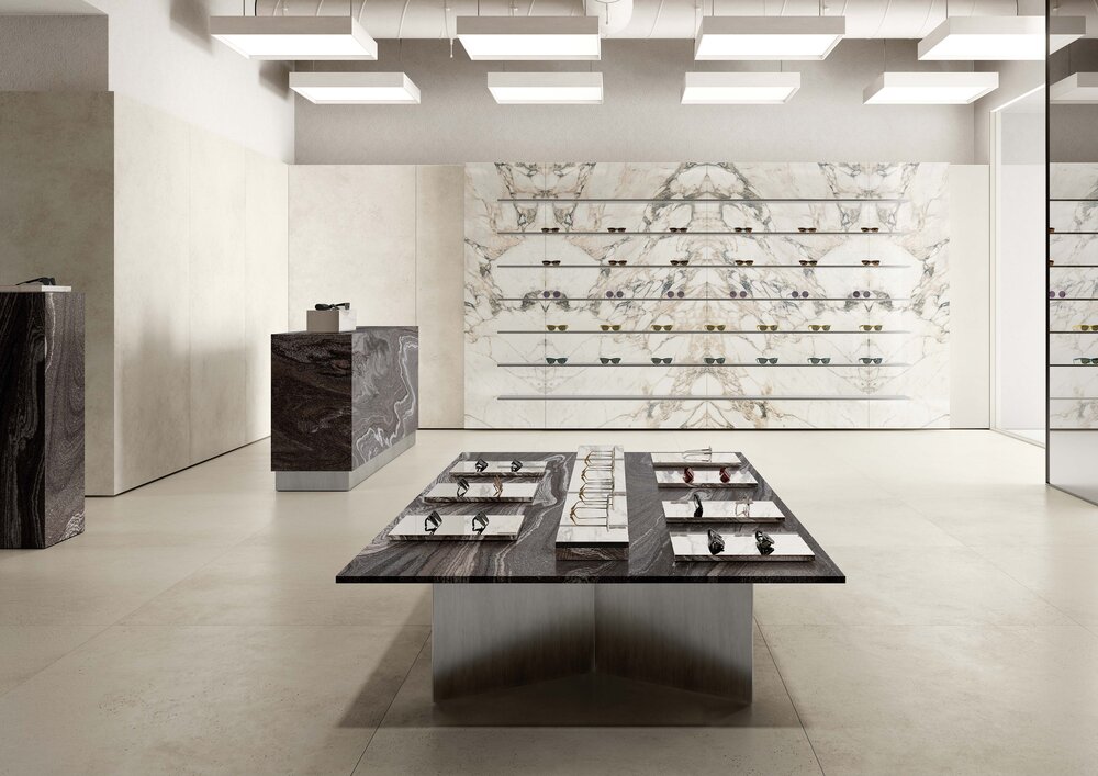 Highlight des Monats Mai 2026 Molarini Betonoptik großformatiger Boden in moderner Ausstellung mit Präsentationstisch und Wandregalen